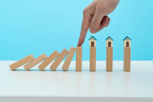 man hand stop dominoes from falling on the house