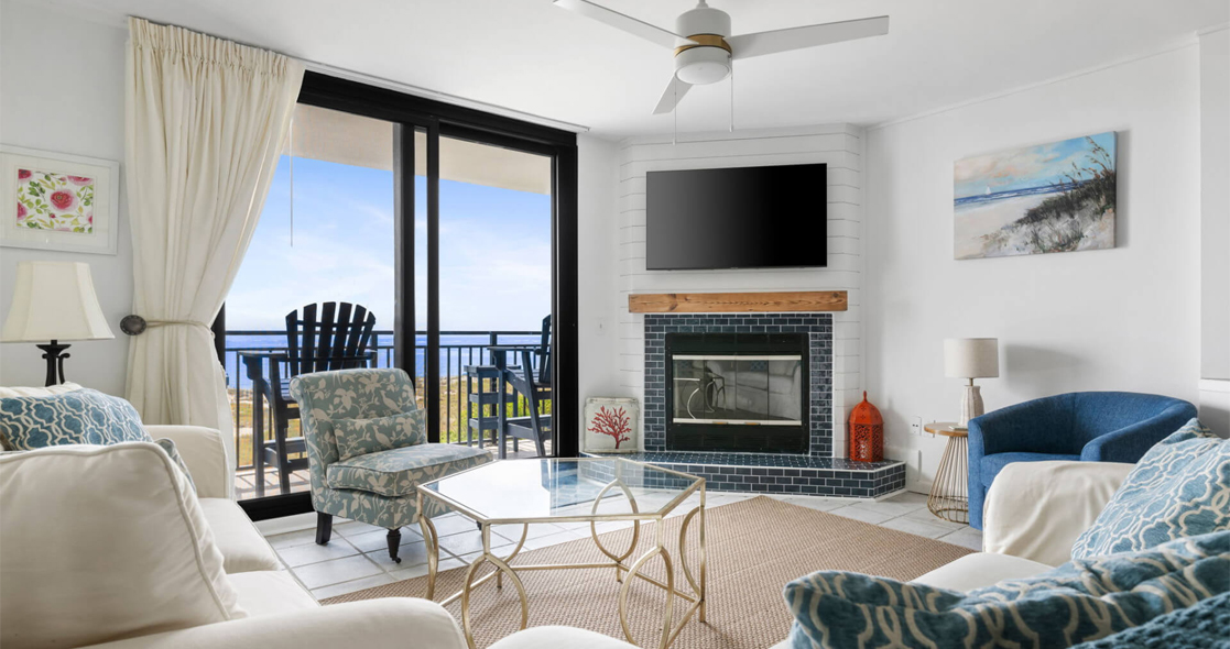 Oceanfront vacation rental living room with fireplace and balcony view