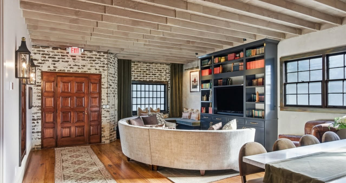 Charleston vacation property featuring a stylish living room with exposed brick walls and elegant furnishings