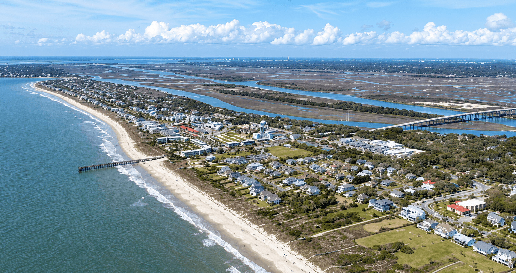 Aerial view of the Isle of Palms coastline with beach homes, sandy beaches, and surrounding marshland.